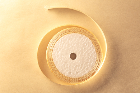 Cream ribbon in roll on paper backgroundの写真素材