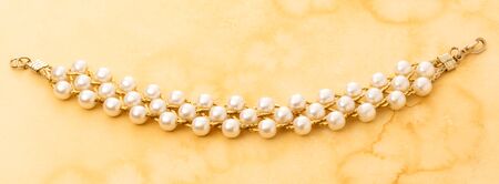 Wristband with golden chain and white beadsの写真素材