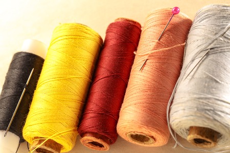 Thread bobbins and needles on paper backgroundの写真素材