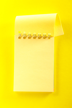 Blank open notebook on the yellow backgroundの写真素材
