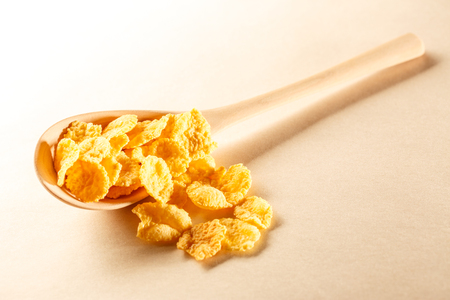 Wooden spoon with corn flakes on paperの写真素材
