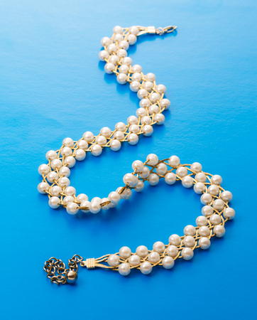 Necklace with golden chain and white beadsの写真素材