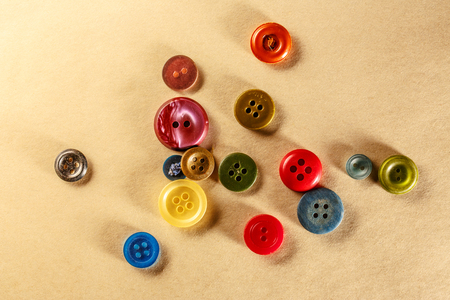 Pile of colourful buttons on paper closeupの写真素材