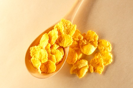 Wooden spoon with corn flakes on paperの写真素材