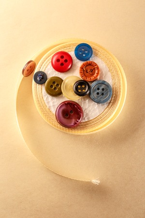 Colourful buttons and ribbon roll in closeupの写真素材