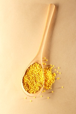 Millet groats with wooden spoon on paperの写真素材