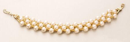 Wristband with golden chain and white beadsの写真素材