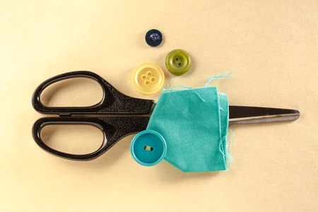 Colourful buttons, scissors and cloth in closeupの写真素材