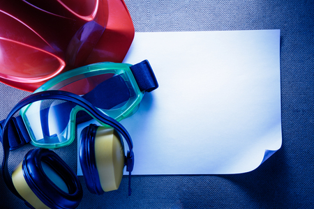 Helmet, earphones, goggles and blank sheet of paperの写真素材