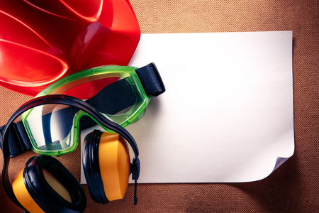 Helmet, earphones, goggles and blank sheet of paperの写真素材