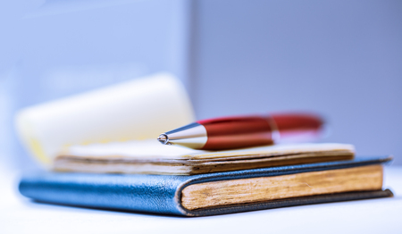 Notebooks with red pen in closeup as backgroundの写真素材