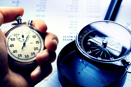 Hand holding stopwatch on budget numbers in closeupの写真素材