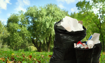Full black wastebasket and plastic bags outsideの写真素材