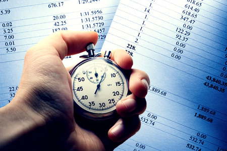 Hand holding stopwatch on budget numbers in closeupの写真素材