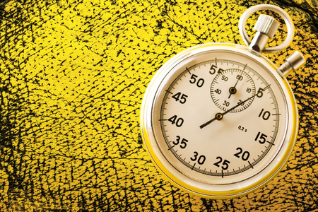 Stopwatch on yellow background in closeupの写真素材