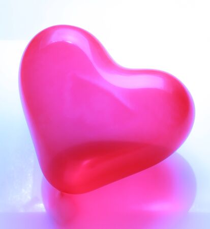 Red heart shaped balloon on white backgroundの写真素材