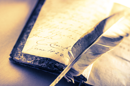Old book with feather pen in toningの写真素材