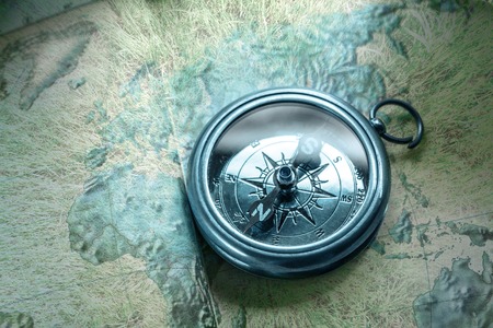 Compass on map background in blue toning