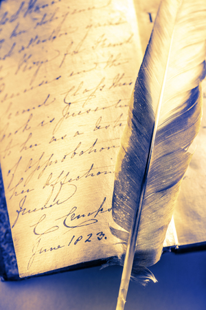 Old book with feather pen in toningの写真素材