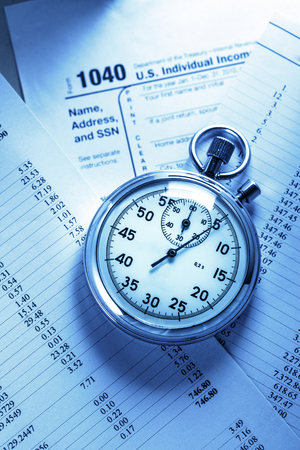 Tax form, operating budget and stopwatch in closeupの写真素材