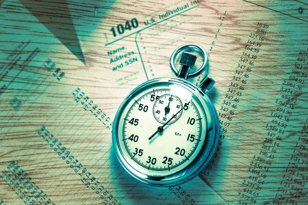 Tax form, operating budget and stopwatch in closeupの写真素材