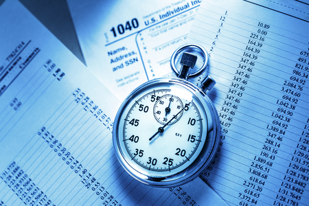 Tax form, operating budget and stopwatch in closeupの写真素材