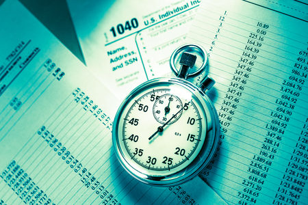 Tax form, operating budget and stopwatch in closeupの写真素材