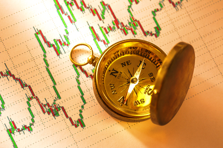 Compass on stock market data chart in closeupの写真素材
