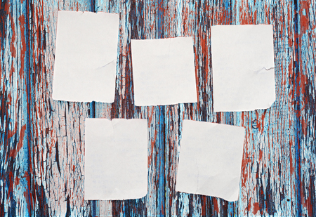 Blank torn scraps of paper on old wooden wallの写真素材
