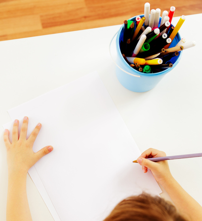 Child's hands with pencil view from aboveの写真素材