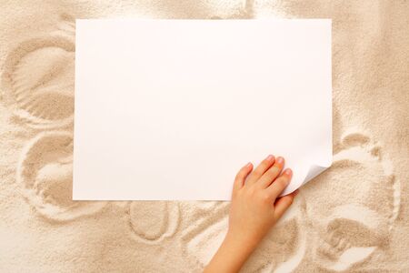 Child's hand turning over sheet of paperの写真素材