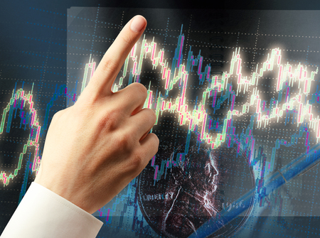 Candlestick chart graphic and pointing hand in lightの写真素材
