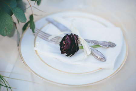 Beautiful table setting. Plate with knife and fork in vintage style. The effect of film photography