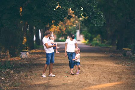 Parents walking on a sand road in the Park with the kids. The effect of film photographyの写真素材