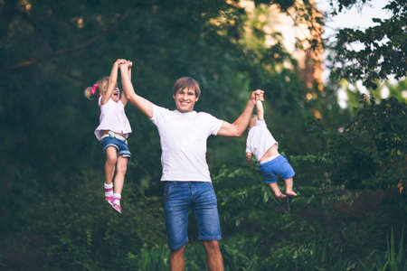Young strong father plays with the children. The effect of film photographyの写真素材