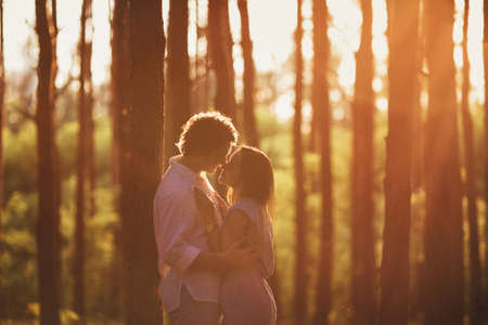 Gentle embrace of the couple in the light. Sunset in the forestの写真素材
