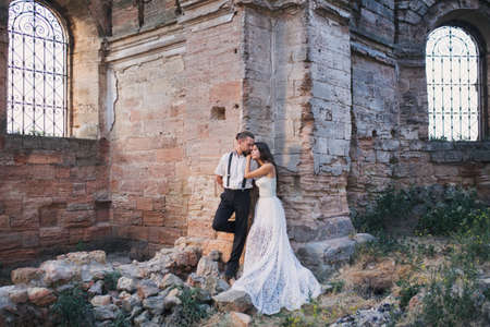 Groom and fiancee in ancient building among ruinsの写真素材