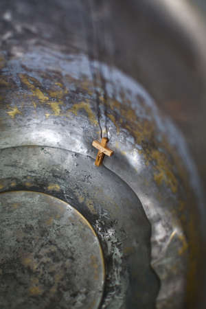 Wooden cross on a thread in an iron tub with waterの写真素材