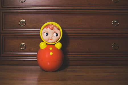 Red tumbler toy on the floor. Russian traditional dollの写真素材