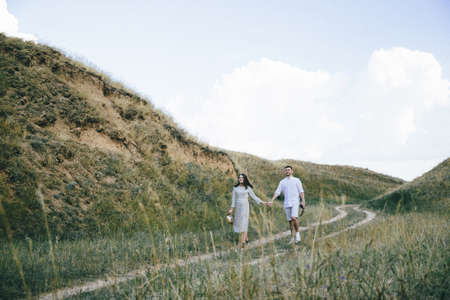 Outdoor portrait of young pregnant couple in fieldの写真素材