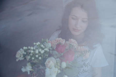 young beautiful girl with the bouquet of colorful flowers.