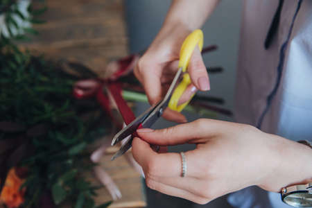 cutting the tape of the bouquet. Florist shop. Florists work.の写真素材