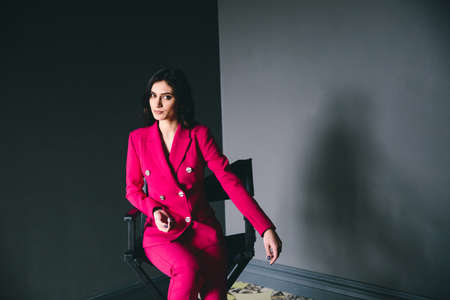 Beautiful woman posing in the studio on the wall backgroungの写真素材