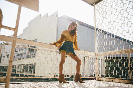 Model posing in a designer costume on the white iron lattice background