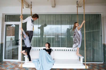 Happy family having fun on a swing ride at a garden a summer dayの写真素材
