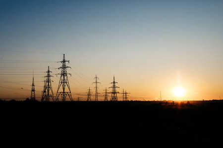 Power lines on the filed on sunset. Save the planet and electricity. Energy Distribution Network -...