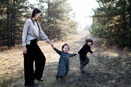 woman with daughter and son are walking one by one in the forest. Live photoの写真素材