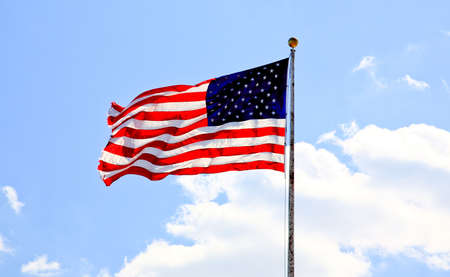 American flag waving against blue sky  の写真素材