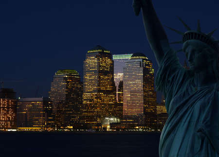The Statue of Liberty and Manhattan Skyline at darkの写真素材