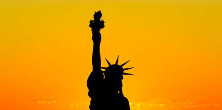The silhouette of Statue of Liberty under sunrise backgroundの写真素材